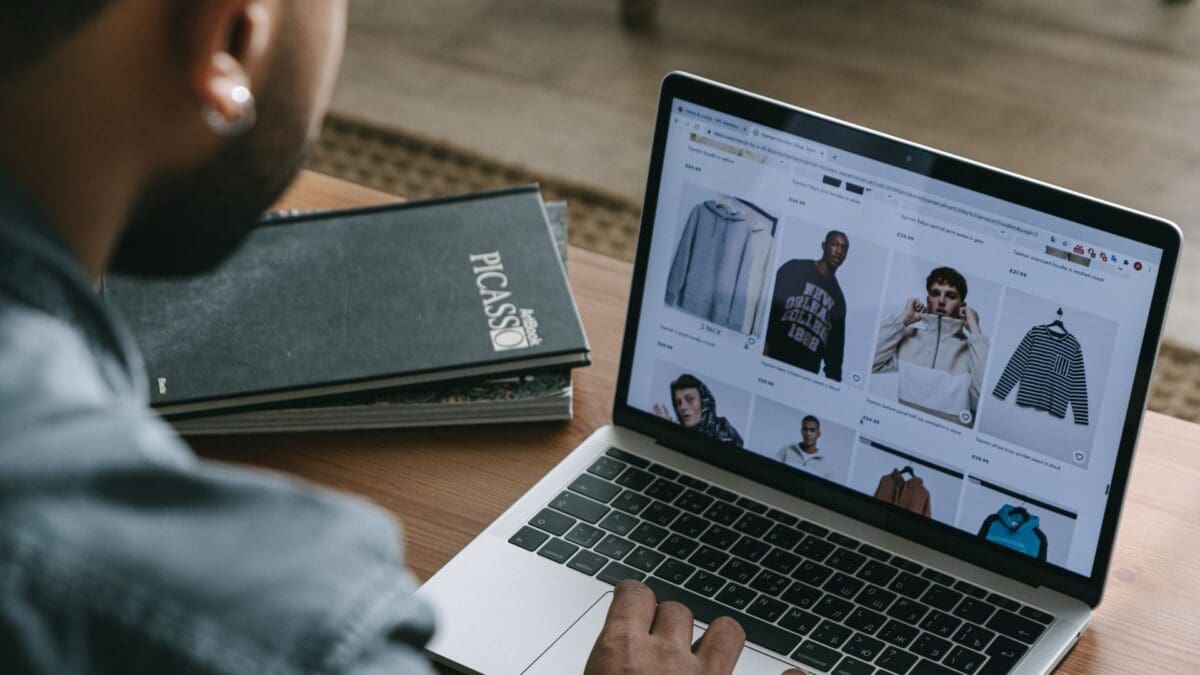 a rear view of a marketer viewing their online clothes store on a laptop