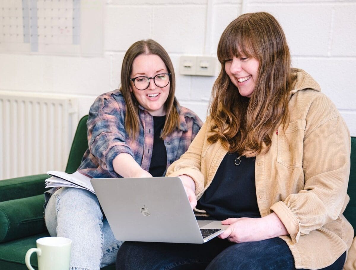 Two women collaborating on a laptop.