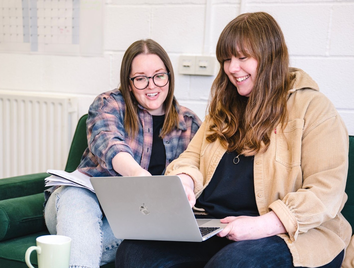 Two women collaborating on a laptop.